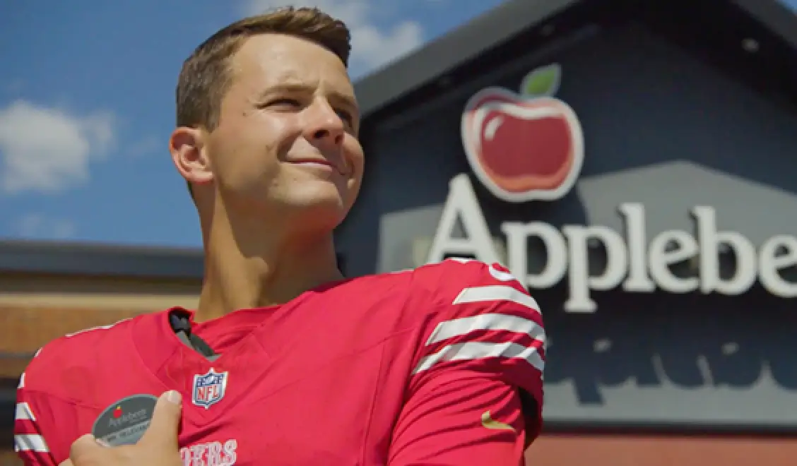 Image of Brock Purdy in front of an Applebee's